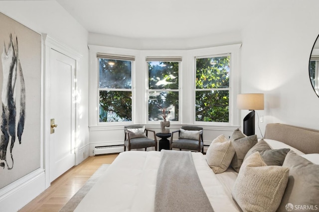 bedroom with baseboard heating and light wood-type flooring