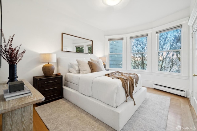 bedroom featuring multiple windows and a baseboard radiator