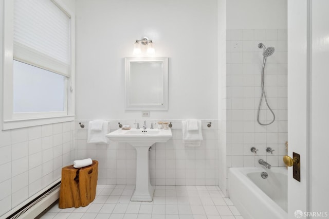 bathroom with tile patterned flooring, tiled shower / bath, tile walls, and a baseboard heating unit