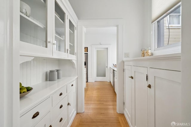 bar with white cabinetry and light hardwood / wood-style flooring