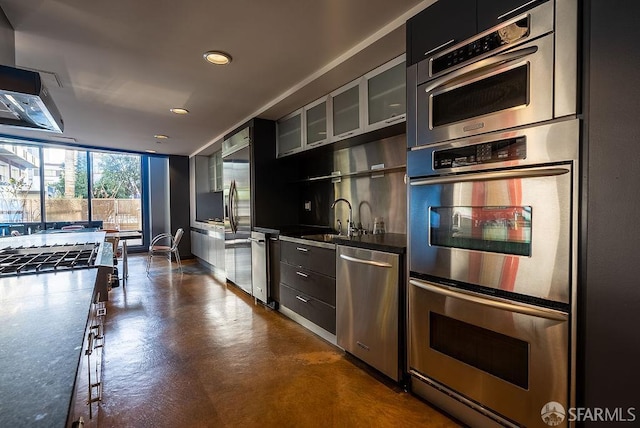 kitchen featuring stainless steel appliances, modern cabinets, concrete floors, recessed lighting, and a sink