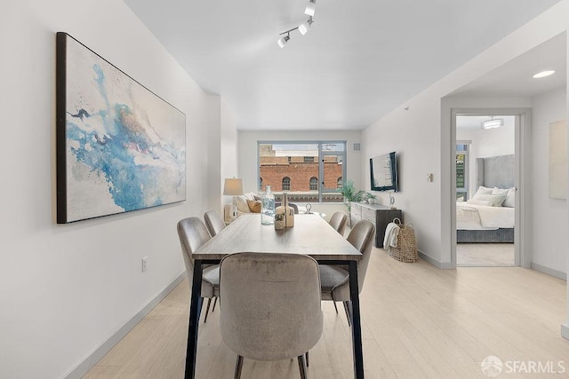 dining room featuring baseboards and light wood-style floors
