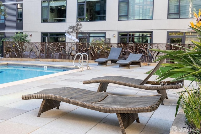 view of swimming pool with fence and a patio area
