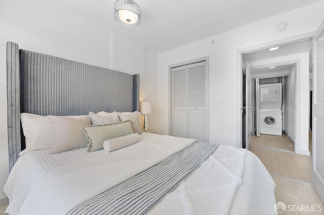 bedroom with estacked washer and dryer, a closet, and recessed lighting