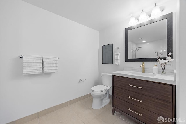 bathroom with toilet, a shower, vanity, baseboards, and tile patterned floors