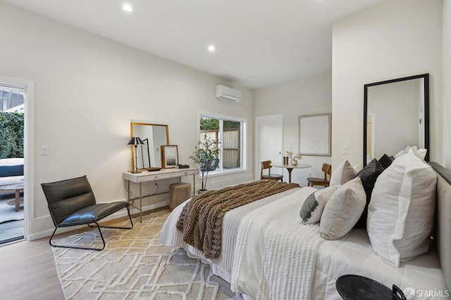 bedroom with an AC wall unit and light hardwood / wood-style floors