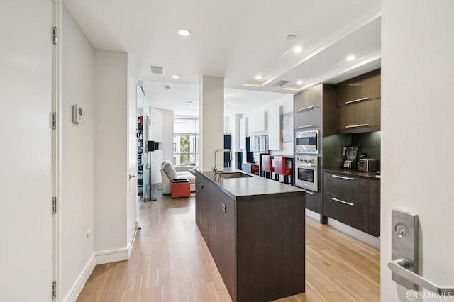 723 Taylor St Unit 402, San Francisco, CA 94109 - kitchen with appliances with stainless steel finishes, modern cabinets, light wood-type flooring, a kitchen island with sink, and recessed lighting
