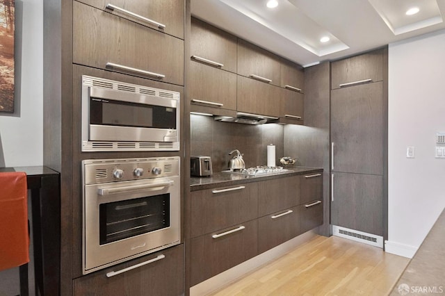 723 Taylor St Unit 402, San Francisco, CA 94109 - kitchen featuring appliances with stainless steel finishes, light wood-style flooring, dark countertops, recessed lighting, and modern cabinets