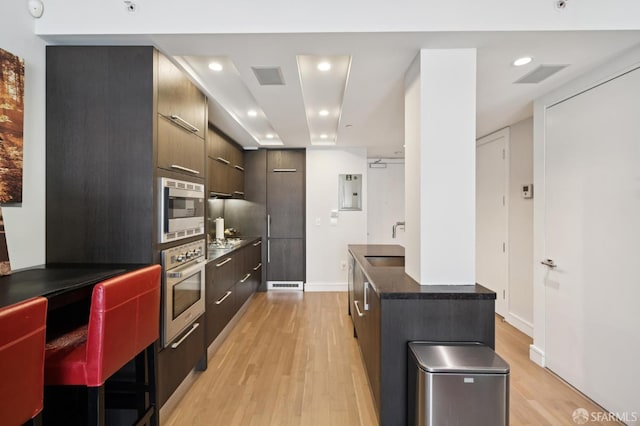 723 Taylor St Unit 402, San Francisco, CA 94109 - kitchen with stainless steel appliances, modern cabinets, dark countertops, light wood finished floors, and recessed lighting