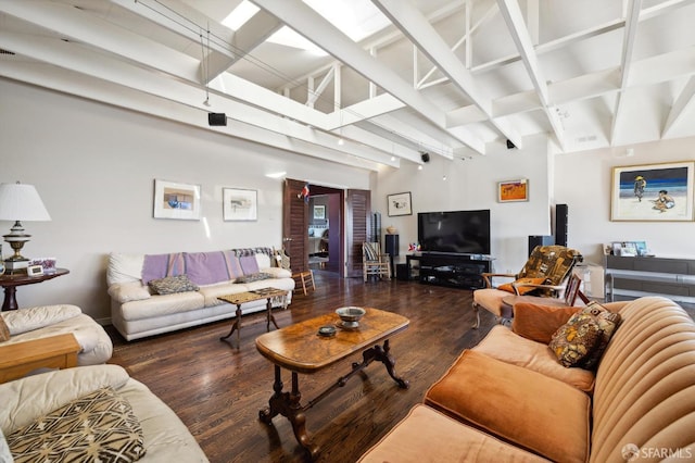 living room with a towering ceiling and dark hardwood / wood-style floors