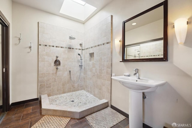 bathroom featuring tiled shower and a skylight