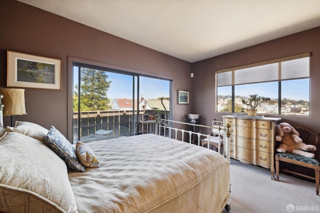 carpeted bedroom with multiple windows and access to outside