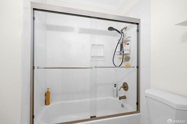 bathroom with toilet, combined bath / shower with glass door, and ornamental molding