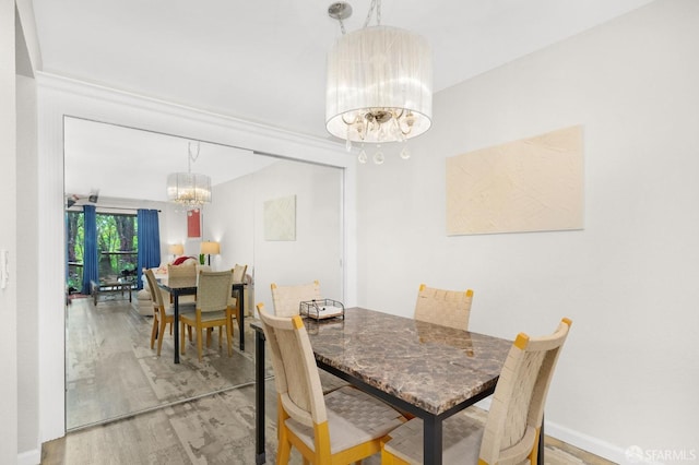 dining room featuring wood-type flooring and a chandelier