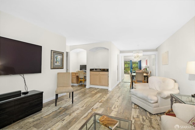 living room featuring a notable chandelier and light wood-type flooring