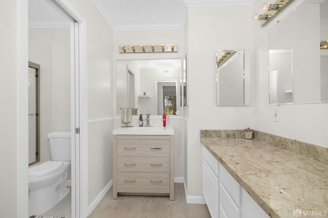 bathroom with toilet, vanity, and crown molding