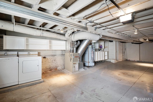 unfinished basement featuring water heater, independent washer and dryer, and heating unit