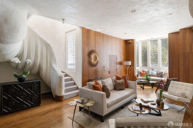 sitting room featuring stairs, wood finished floors, and wooden walls