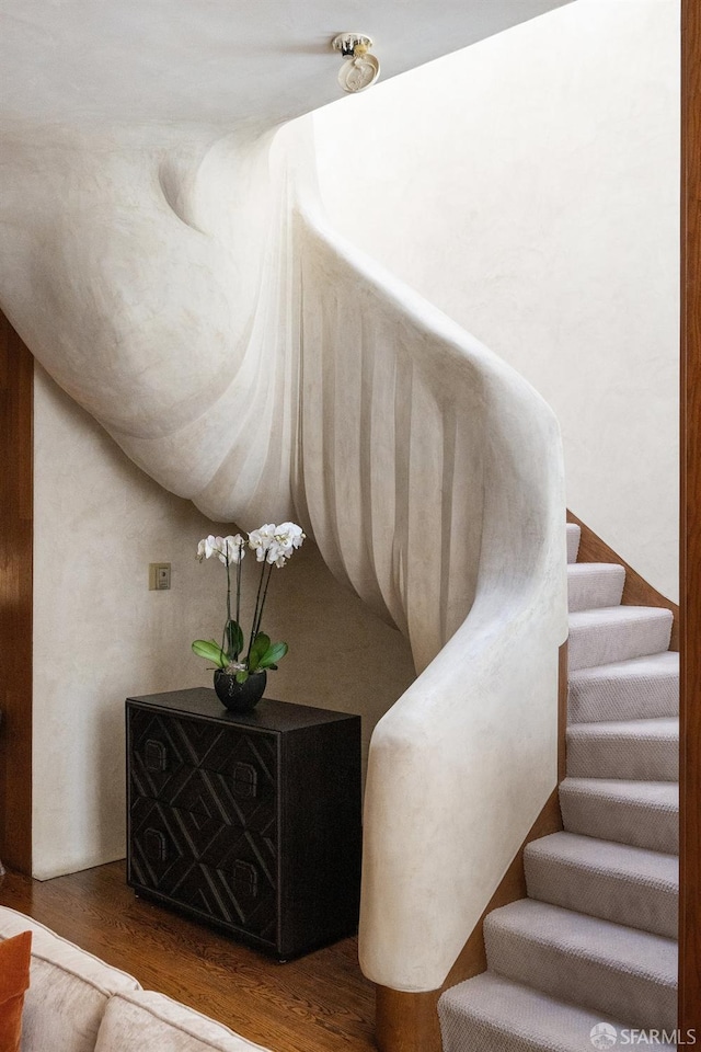 stairway with lofted ceiling and wood finished floors