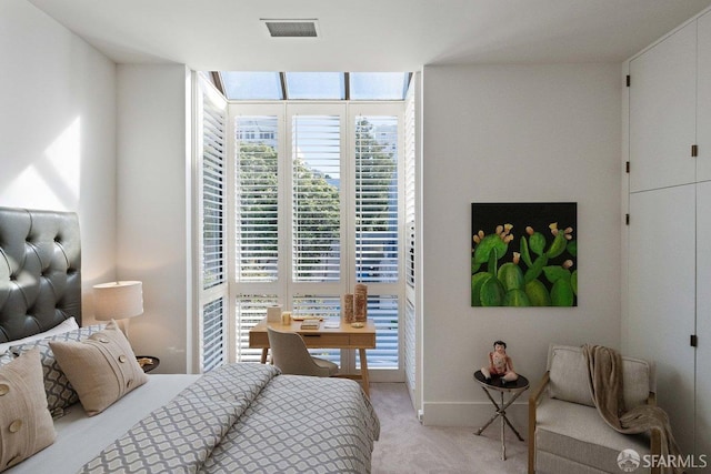 bedroom featuring a wall of windows, visible vents, and light carpet