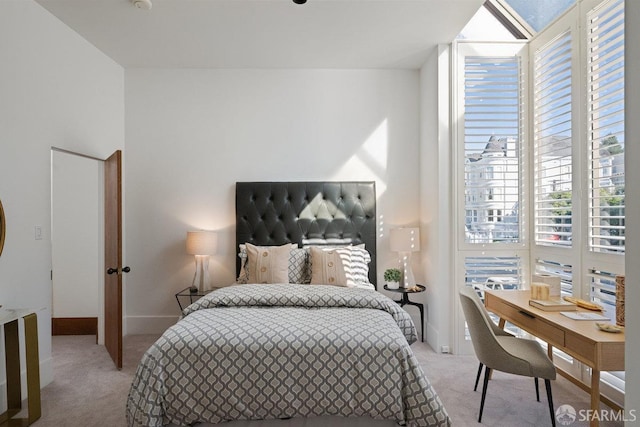 bedroom featuring light carpet and baseboards