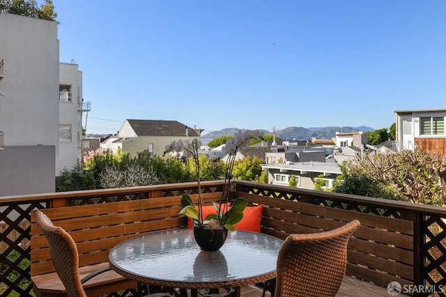 balcony with outdoor dining space, a residential view, and a mountain view