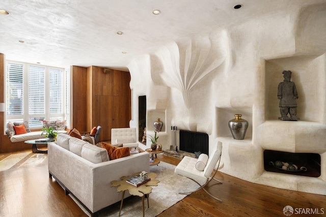 living area featuring a large fireplace and wood finished floors