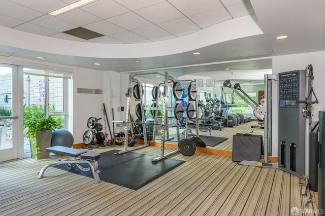 gym with a drop ceiling and carpet floors