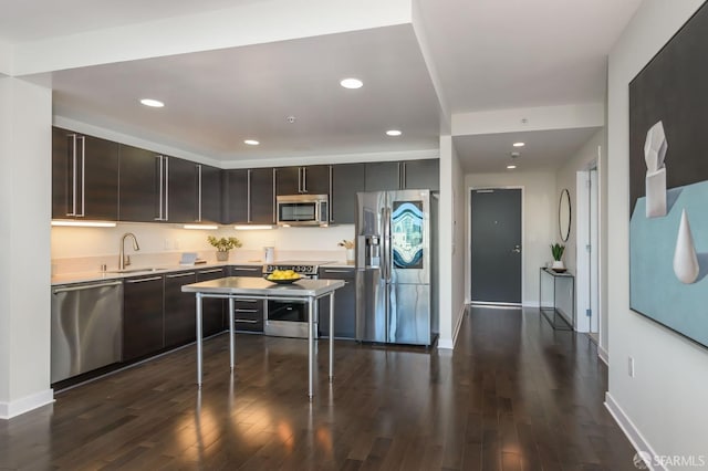 kitchen with dark brown cabinets, sink, stainless steel appliances, and dark wood-type flooring