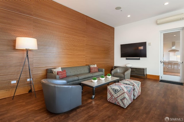 living room featuring an AC wall unit and dark hardwood / wood-style floors