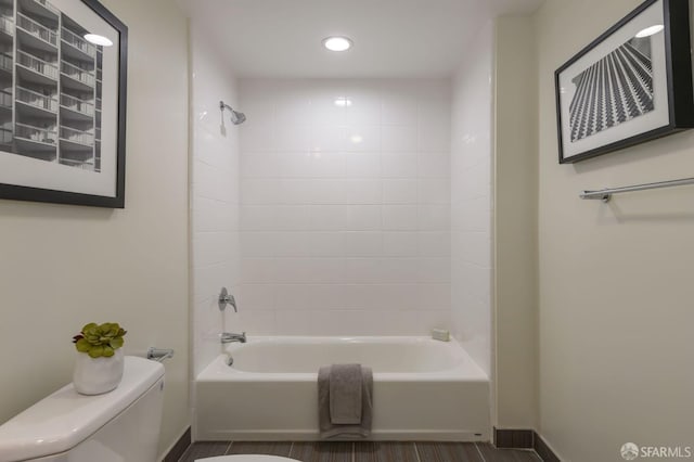 bathroom featuring tiled shower / bath and toilet