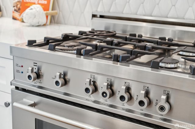 details with backsplash and stainless steel gas range oven