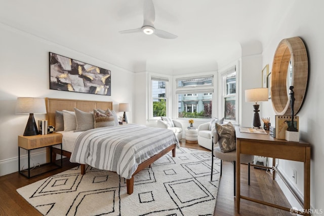 bedroom with ceiling fan, wood finished floors, and baseboards