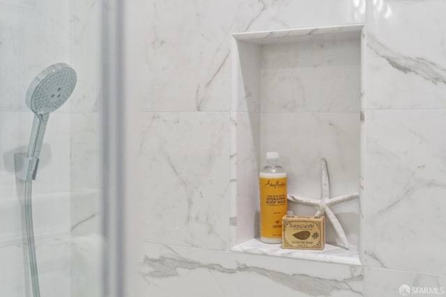 interior details featuring a marble finish shower