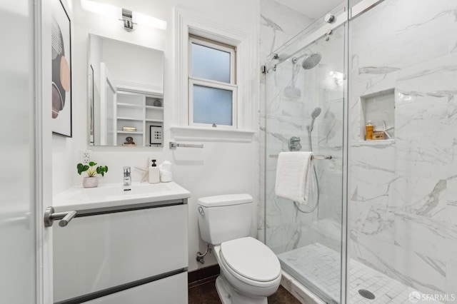 bathroom with vanity, a marble finish shower, and toilet