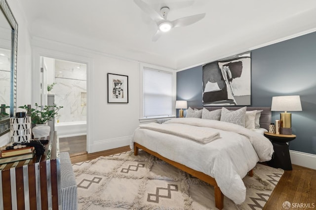 bedroom featuring ensuite bathroom, wood finished floors, a ceiling fan, and baseboards