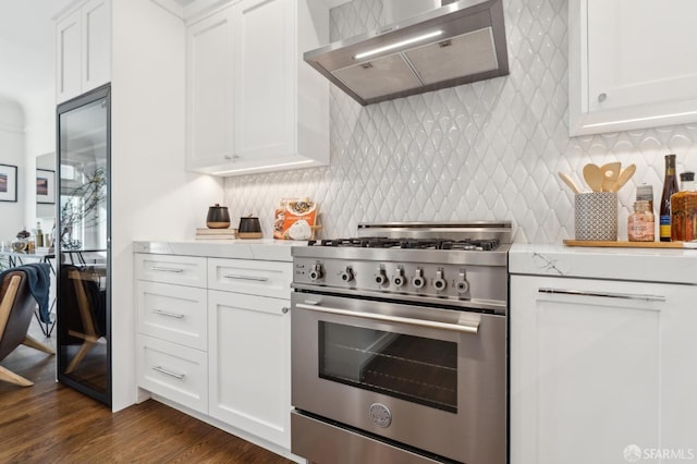 kitchen with ventilation hood, high end stainless steel range, backsplash, and white cabinetry