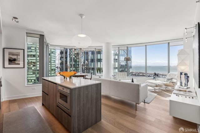 kitchen featuring modern cabinets, light countertops, plenty of natural light, and wood finished floors