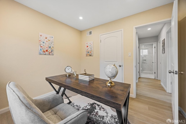 home office with light hardwood / wood-style flooring