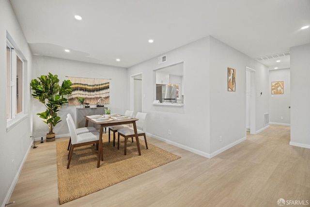 dining space with light hardwood / wood-style flooring