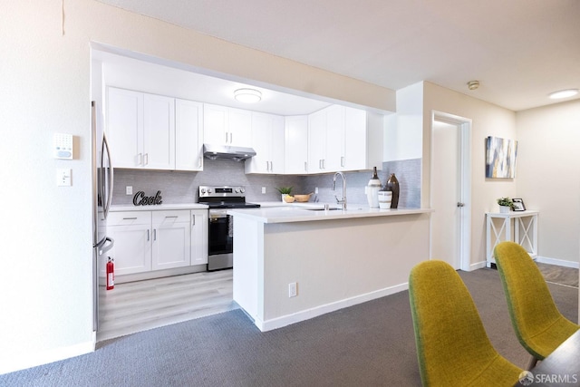 1360 9th Ave Unit 7, San Francisco, CA 94122 - kitchen featuring stainless steel appliances, tasteful backsplash, a peninsula, light countertops, and light carpet