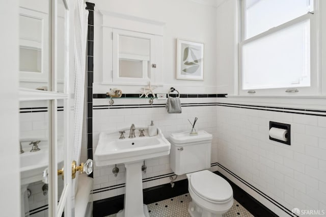 1205 Oak St Unit 2, San Francisco, CA 94117 - full bathroom featuring a baseboard heating unit, tile patterned flooring, tile walls, a shower with shower curtain, and wainscoting