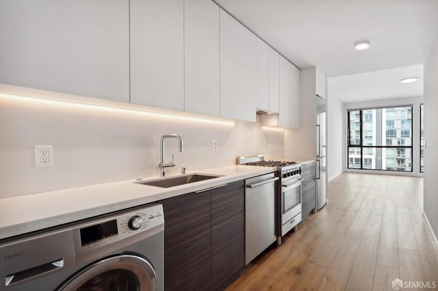 1433 Bush St Unit 702, San Francisco, CA 94109 - kitchen featuring washer / clothes dryer, white cabinetry, sink, and stainless steel appliances