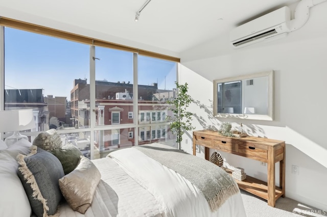 bedroom featuring multiple windows, a wall mounted AC, and track lighting