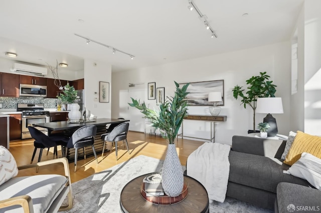 living room featuring light hardwood / wood-style floors and an AC wall unit