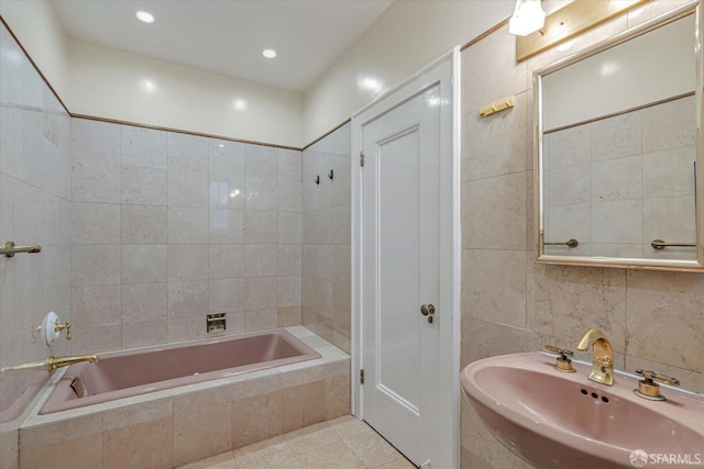 bathroom with tile patterned floors, sink, and tile walls