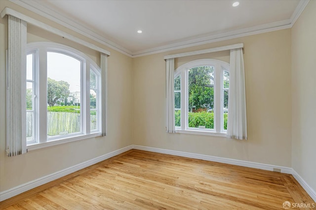 unfurnished room with crown molding, light hardwood / wood-style floors, and a healthy amount of sunlight