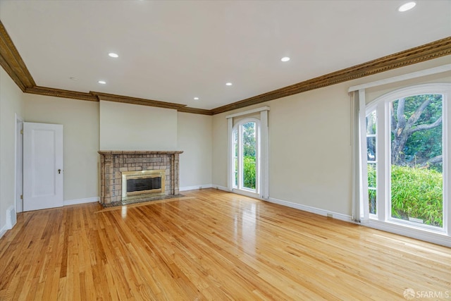 unfurnished living room featuring crown molding, light wood-type flooring, and a fireplace