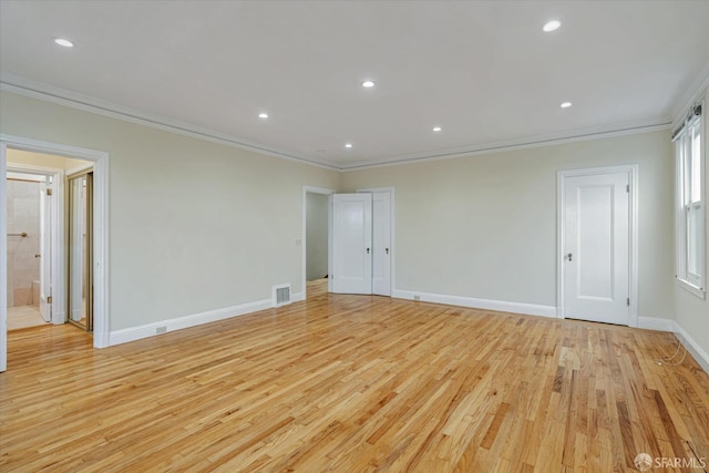 empty room featuring ornamental molding and light wood-type flooring