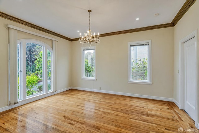 unfurnished dining area with ornamental molding, a chandelier, and light hardwood / wood-style flooring